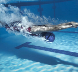 Frau taucht gerade in ein Schwimmbecken ein